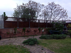 Dřevěné plotové zástěny přichycené na kovové plotové sloupky je jedna z možností stavby plotu k podezdívce.