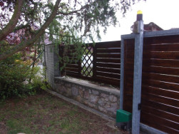 Detail výplně pojezdových vrat ve stejném stylu jako zbývající zahradní plot.