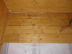 Zateplenou podlahu jsme překryli smrkovými palubkami o síle 28 mm, nakonec jsme podlahu po obvodu ukončili připravenými lištami
