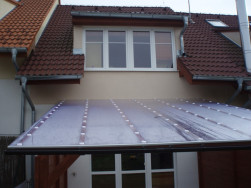Polykarbonátová střecha pergoly ukotvené ke zdi domu