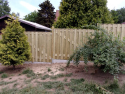 Jednotlivé plotové dílce jsou kotveny na dřevěné plotové sloupky