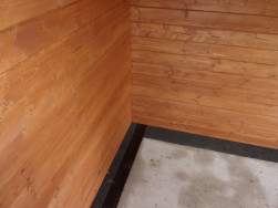 Mezi stěny chaty a betonovou plochu byl položen izolační pás  k zamezení prostupu vlhkosti do dřeva.