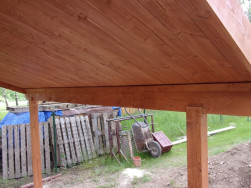 Na dvou stojinách je připevněné dřevěné ráhno, které drží střešní přístřešek.
