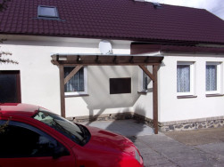 Pergola pro posezení v rohové části domu.