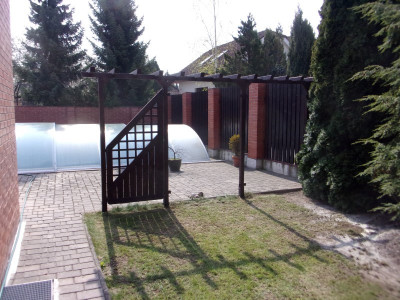 Dřevěná pergola s dělící stěnou pro rozčlenění zahrady