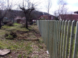 Dlouhé plotové dílce mezi kovovými sloupky vyztuženy sloupky dřevěnými.