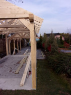 Konstrukce zahradního domku s krovem  ještě před opláštěním a volně na něj navazující garážové stání