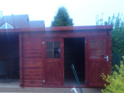 Zahradní domek s posezením má pultovou střechu a dvoukřídlé, částečně prosklené dveře