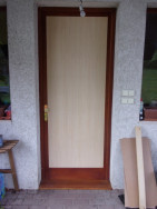 Na dveře z vnější strany byla nalepena dřevěná deska zakrývající původní poškozený dekor