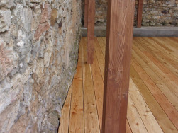 Dřevěná prkna podlahy jsme přizpůsobili zakřivení kamenné zdi