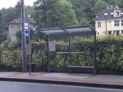 Moderní autobusové zastávka v kombinaci žárově zinkované kovové konstrukce a plexiskla a doplněna o dřevěný sedák lavičky