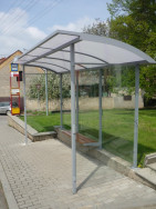 Moderní autobusové zastávka v kombinaci žárově zinkované kovové konstrukce a plexiskla lišící se tvarem střechy