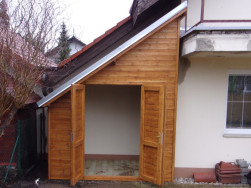 Součástí domku na nářadí jsou dřevěné dvoukřídlé dveře, kdy jedna část je jištěna horní a dolní dveřní zástrčí, druhá polovina na kliku se zámkem.