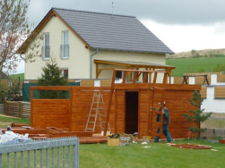 Zahradní domky propojené zastřešeným prostorem jsou vyrobeny ze smrkového dřeva o síle 28 mm