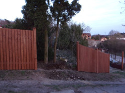 Před instalací posledního plotového pole musely být ořezány větve vzrostlé borovice