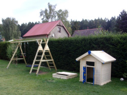 Dětský dřevěný domek má modro-žluté plastové dveře a okenice