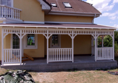 Bílá pergola zastřešená hnědým asfaltovým šindelem