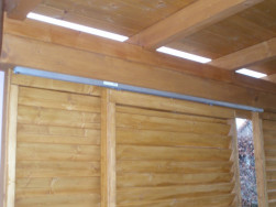 Zahradní pergola zastřešená palubkou na kterém je položený střešní šindel