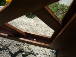 Detail dřevěného rámu mříže s otvorem pro odtok dešťové vody