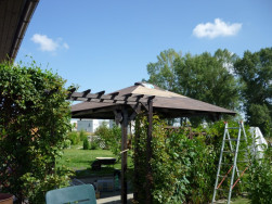 Pod zastřešeným zahradním altánem se rodině bude dobře relaxovat