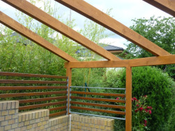 Nezastřešená pergola byla po stranách doplněna kovovými rámy s laťovou výplní