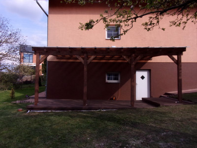 Opěrná pergola doplněná hnědou kompozitní podlahou  