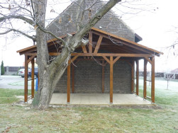 Zastřešená pergola byla postavena natěsno k cihlové zdi staré stodoly