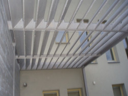 Střechu zahradní pergoly tvořily pod určitým úhlem umístěné dřevěné lamely