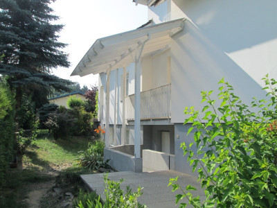 Bílá pergola pro překrytí malého balkonu a vstupu do suterénu