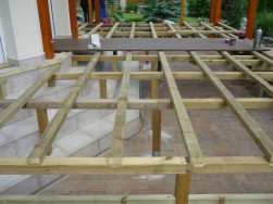 Ro&scaron;t z impregnovan&yacute;ch hranolů navazuje na vstup do domu