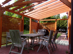 Zabydlená hotová zahradní pergola připravená pro rodinné grilování