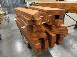 Dřevěn&eacute; hranoly na veřejn&eacute; p&iacute;skovi&scaron;tě doplněn&eacute; o horn&iacute; dřevěn&yacute; rantl slouž&iacute;c&iacute; jako lavička