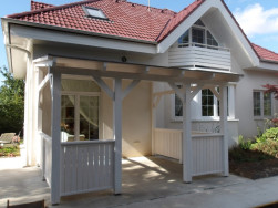 Bílá pergola se zábradlím krásně ladí s domem a jeho okolím