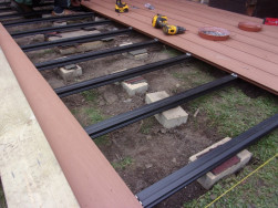 Mezi dlaždici a ro&scaron;t jsme vložili tlum&iacute;c&iacute; gumu