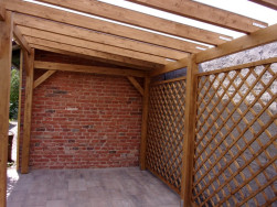 Mř&iacute;ž s velikost&iacute; oka 10 x 10 cm jsme k pergolov&yacute;m stojk&aacute;m připevnili pomoc&iacute; kovov&yacute;ch &uacute;heln&iacute;ků