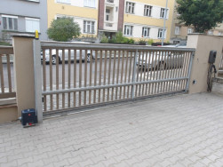 Povrchov&aacute; &uacute;prava dřevěn&eacute;ho plotu byla provedena v &scaron;ed&eacute;m odst&iacute;nu lazurou Tikkurila