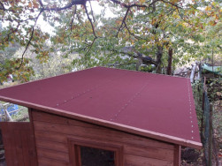 Na plochu pultov&eacute; střechy jsme připevnili červenou asfaltovou lepenku