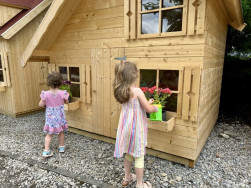 Děti si v domečku hraj&iacute;, ale současně se i staraj&iacute; o květiny v truhl&iacute;c&iacute;ch