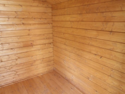 Vnitřek domku s dřevěnou podlahou o&scaron;etřenou stejnou lazurou
