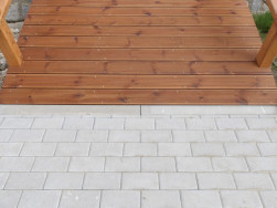 Dřevěn&aacute; l&aacute;vka plynule navazuje na dl&aacute;žděn&yacute; chodn&iacute;k z obou stran