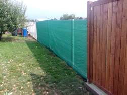 Děl&iacute;c&iacute; dřevěn&eacute; stěny se k plotov&yacute;m sloupkům upevnili kovov&yacute;mi &uacute;heln&iacute;ky