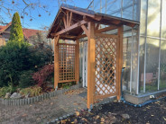 Přístřešek nad široké dveře s bočními zástěnami z ozdobných mříží