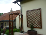 Pergola s mříží a velká mříž v rámu připevněná na zeď